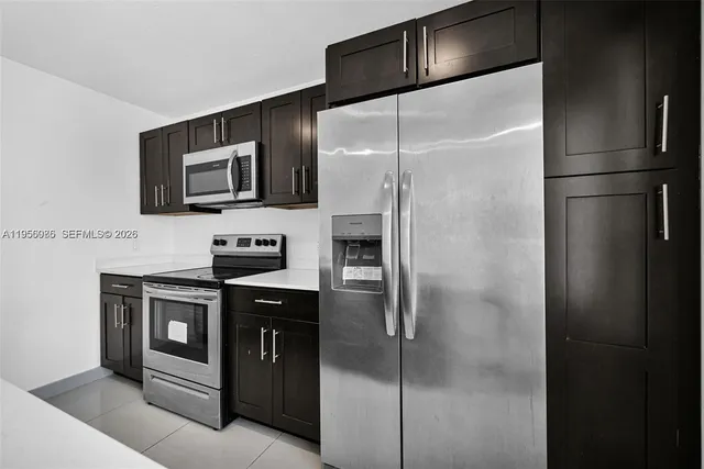 a kitchen with stainless steel appliances granite countertop a refrigerator and a stove top oven