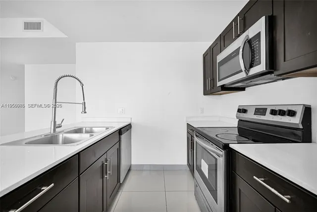 a kitchen with stainless steel appliances granite countertop a sink a stove and cabinets
