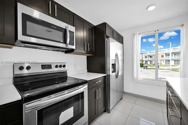 a kitchen with stainless steel appliances a stove microwave and refrigerator