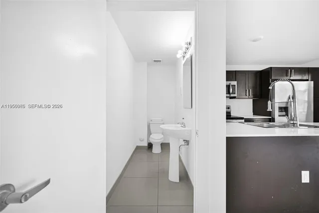 a view of a kitchen with refrigerator and a sink