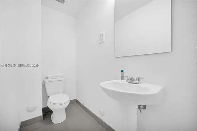 a white toilet sitting next to a bathroom sink