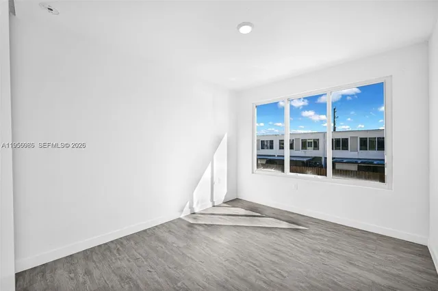 a view of a room with wooden floor and white walls