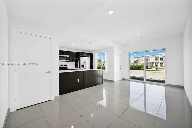 a view of kitchen with a sink and a refrigerator