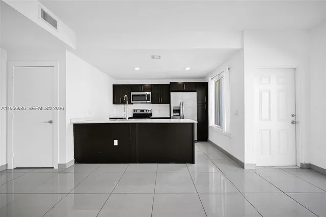 a kitchen with stainless steel appliances a refrigerator and a sink