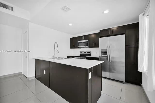 a kitchen with a sink a refrigerator and a microwave
