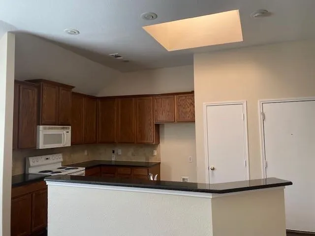 a kitchen with stainless steel appliances granite countertop a sink stove and microwave