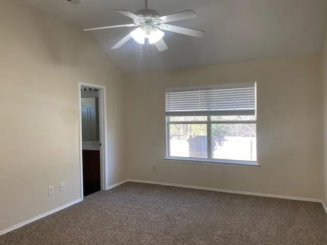 an empty room with a window and a fan
