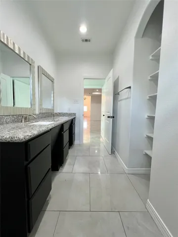 a spacious bathroom with a granite countertop sink a toilet and a mirror