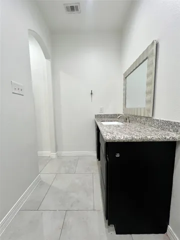 a bathroom with a granite countertop sink and a mirror