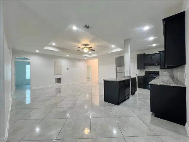 a large kitchen with a large counter top and living room