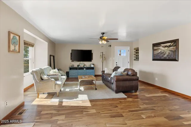 a living room with furniture a flat screen tv and a fireplace