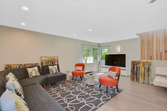 a living room with furniture a flat screen tv and a couch