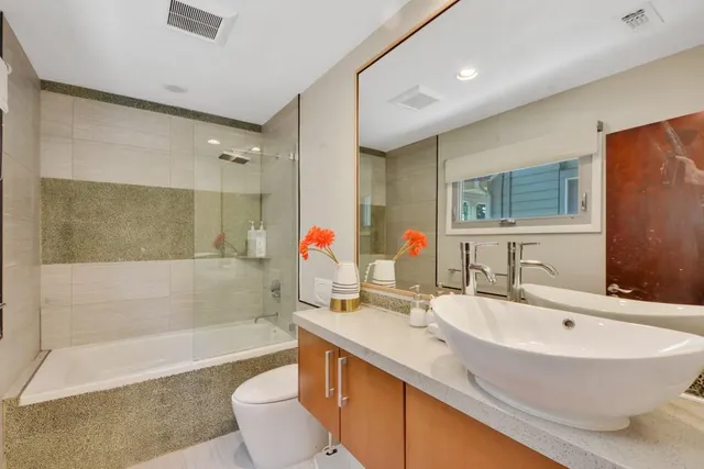 a bathroom with a sink a toilet and shower