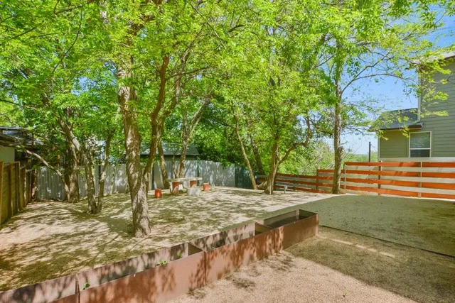 a view of backyard with wooden fence