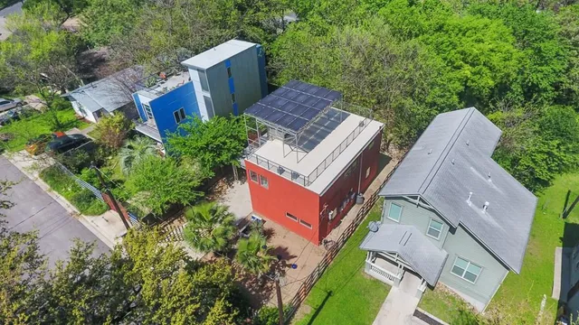 an aerial view of a house with a yard and large trees
