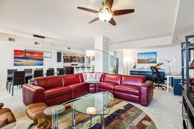 a living room with furniture a flat screen tv and kitchen view