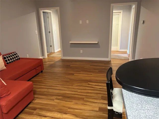 a dining room with furniture a chandelier and wooden floor