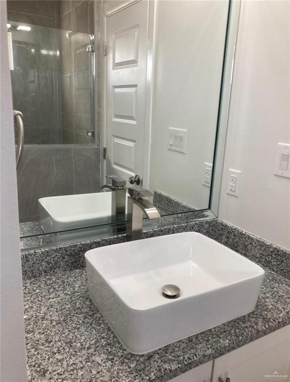 1411 South Flag Street, Unit 1 Pharr, TX 78577 - Photo 6 of 12 a bathroom with a tub a sink and a large mirror