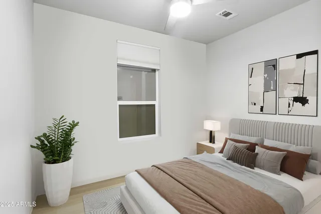 a bedroom with a bed and a potted plant