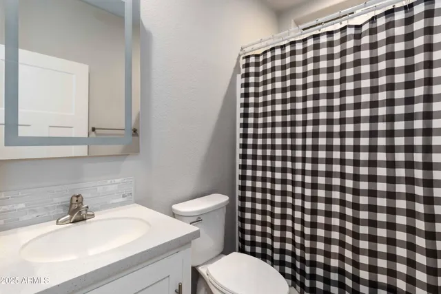a bathroom with a sink toilet and a mirror