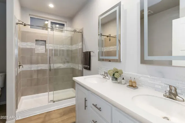 a bathroom with a shower sink and mirror