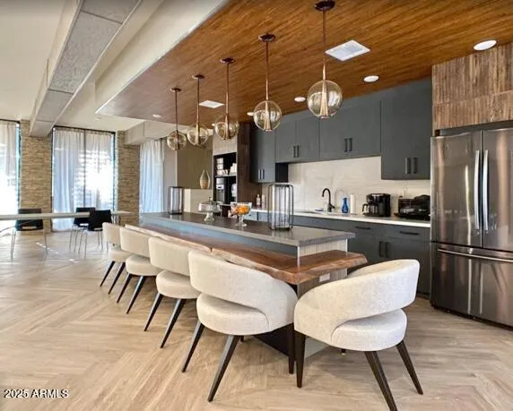 a kitchen with a dining table chairs and refrigerator