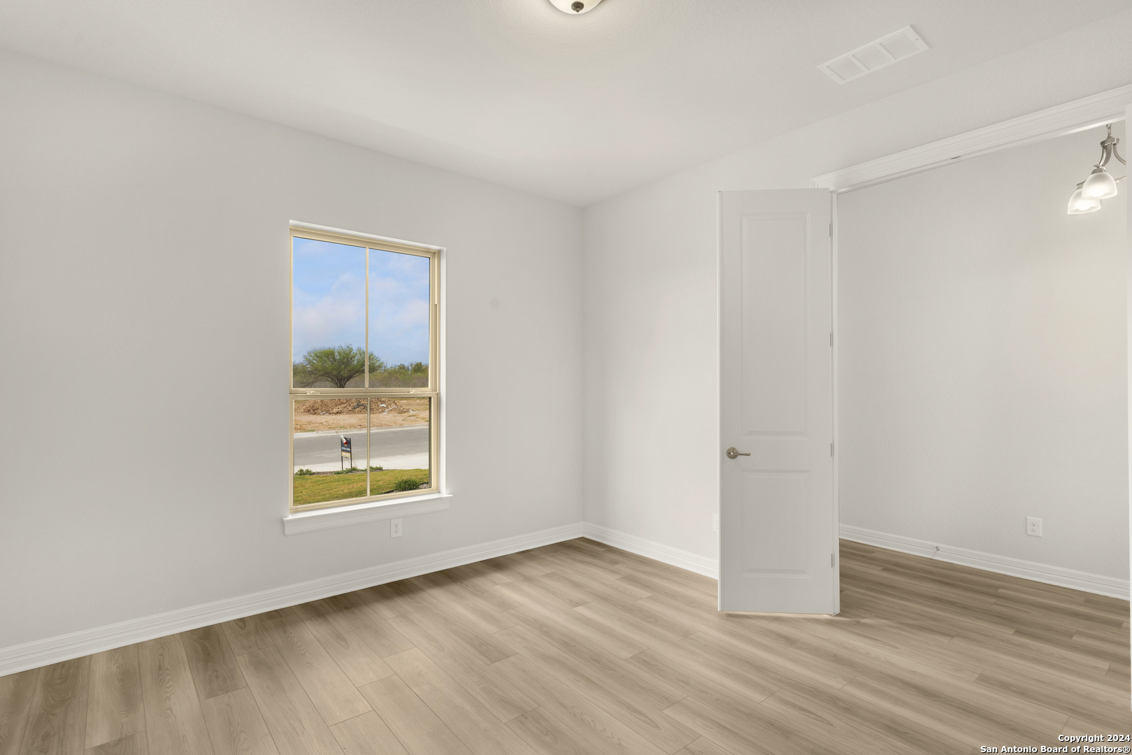 948 Nolte Bend Seguin, TX 78155 - Photo 4 of 39 an empty room with wooden floor and windows
