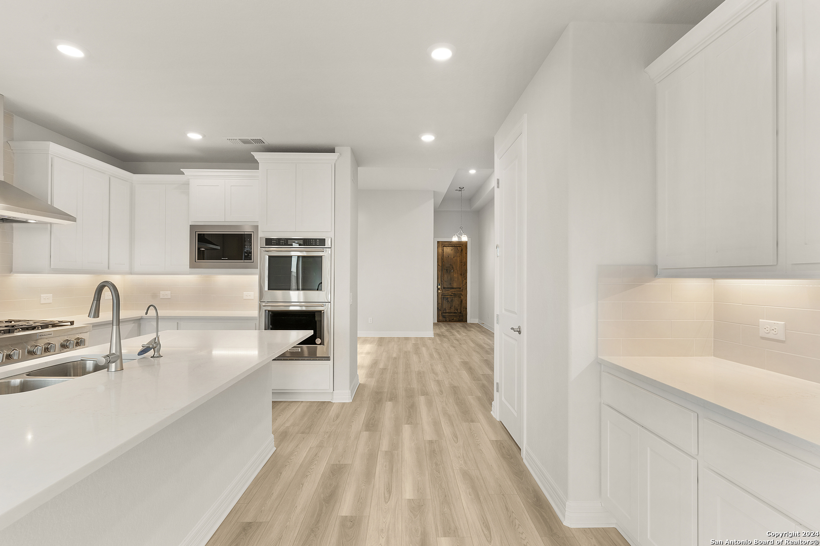 948 Nolte Bend Seguin, TX 78155 - Photo 10 of 39 a large white kitchen with a lot of counter space and wooden floor