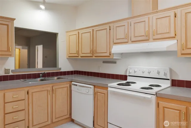 a kitchen with granite countertop white cabinets and white appliances