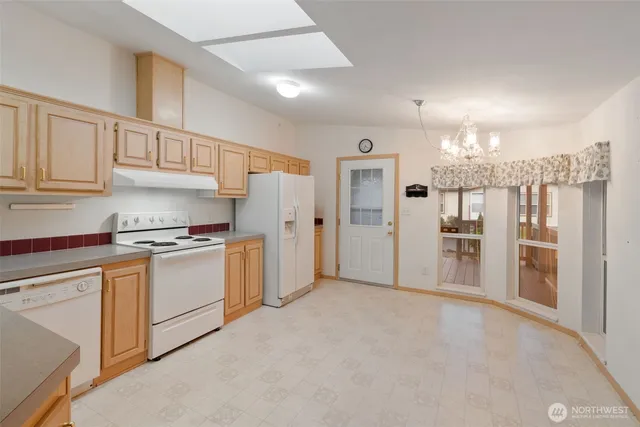 a kitchen with white cabinets and refrigerator