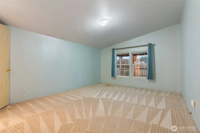 a view of a bedroom with a bed and a window