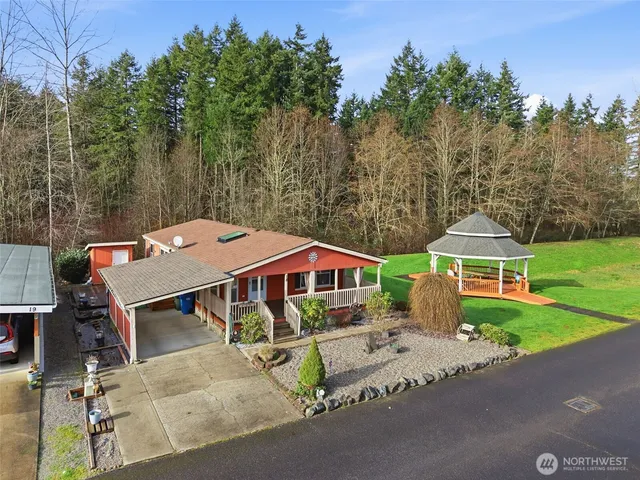 an aerial view of a house with garden space and trees in the background