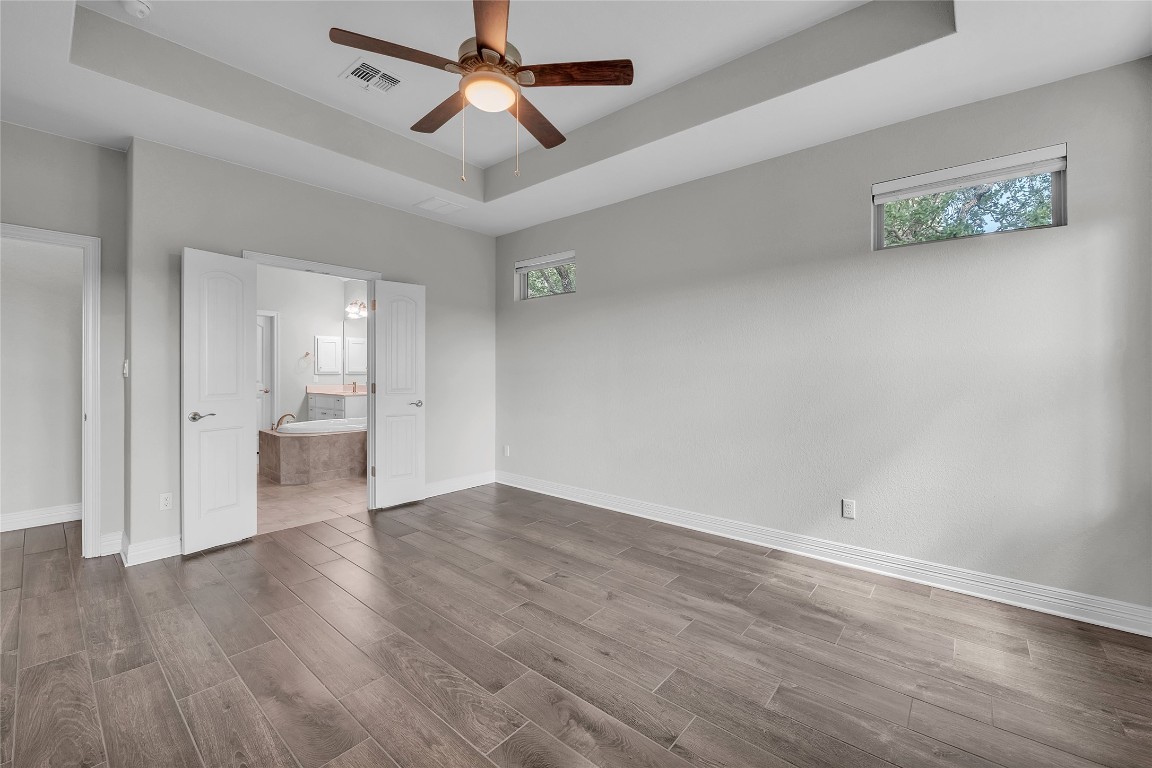 221 Cibolo Ridge Drive Georgetown, TX 78628 - Photo 17 of 27 an empty room with wooden floor a ceiling fan and kitchen view