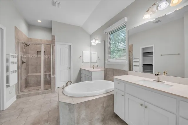 a bathroom with a sink a toilet a large mirror and shower