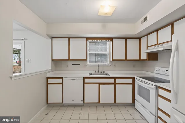 a kitchen with a stove sink and cabinets