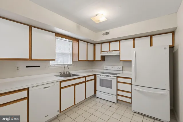 a kitchen with white cabinets and white appliances