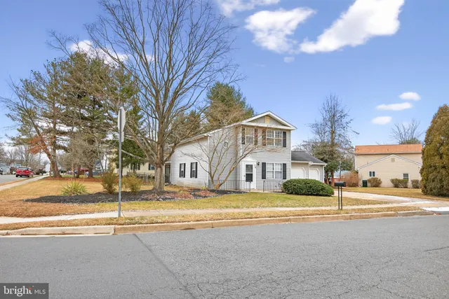 a view of a white house with a road next to a building
