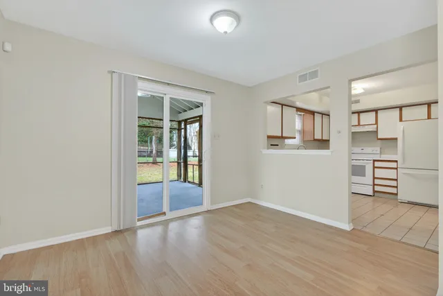 a view of a kitchen with wooden floor and a hallway