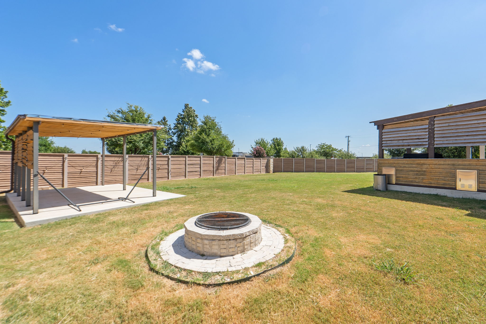 142 Brunnen Way Georgetown, TX 78626 - Photo 22 of 22 An inviting backyard oasis awaits, complete with a covered patio, fire pit, and outdoor kitchen.