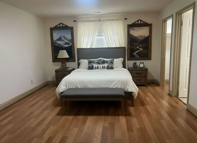 a bedroom with a bed a mirror and a window