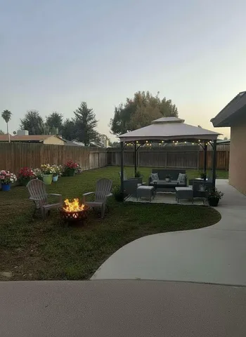 a view of a house with backyard and sitting area