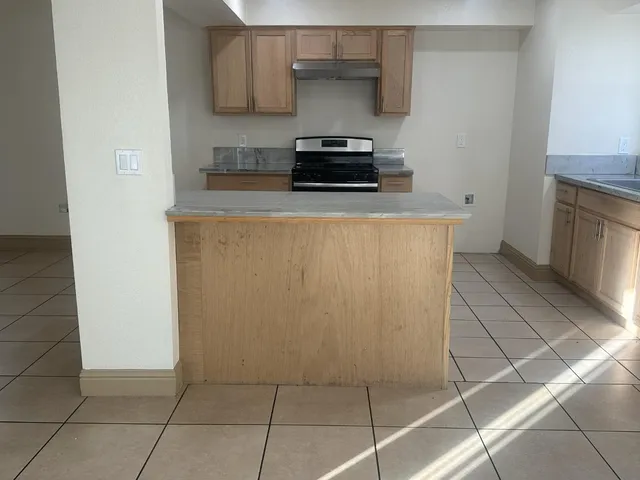 a kitchen with granite countertop a stove a microwave and a sink