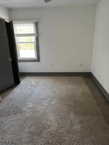 a view of a livingroom and window in an empty room