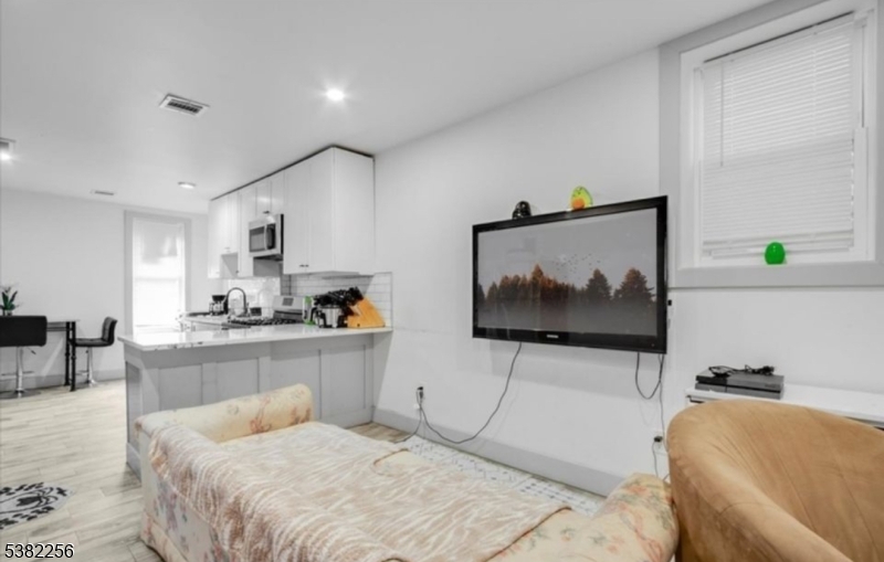 53 2nd Avenue, Unit 2 Newark, NJ 07104 - Photo 3 of 7 a living room with furniture and a flat screen tv