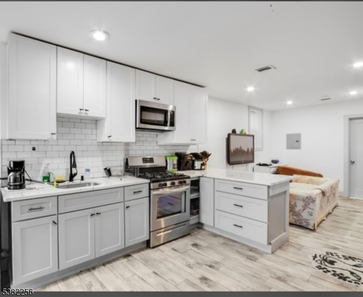 53 2nd Avenue, Unit 2 Newark, NJ 07104 - Photo 4 of 7 a kitchen with a sink stove and cabinets