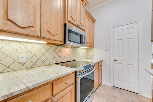 a kitchen with granite countertop white cabinets and stainless steel appliances