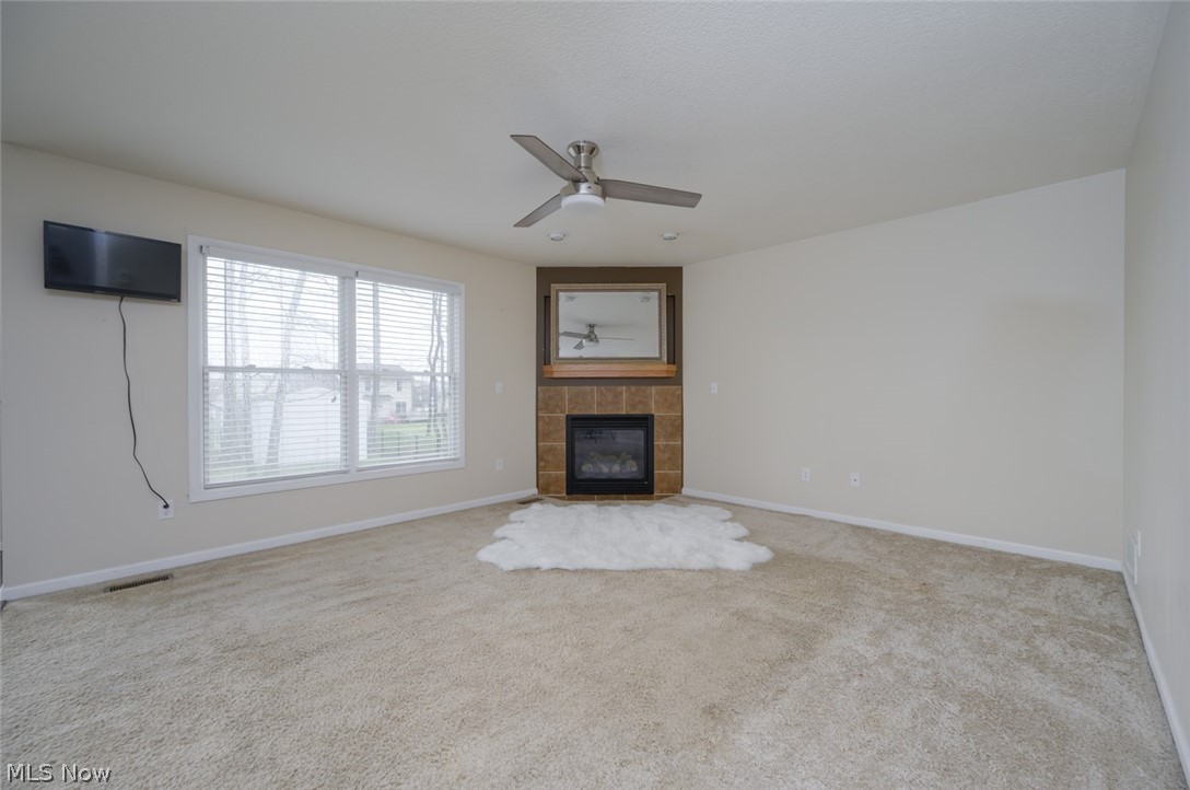 1060 Susan Road Ravenna, OH 44266 - Photo 5 of 25 spacious living room with a fireplace, light carpet, and ceiling fan