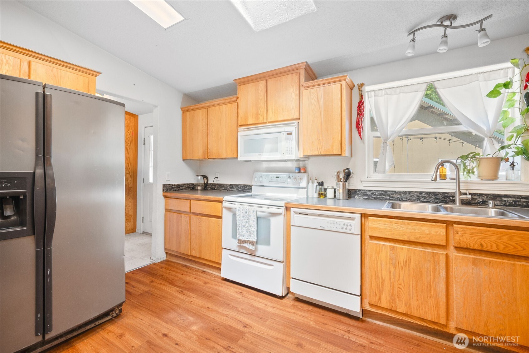 4230 Cody Road Blaine, WA 98230 - Photo 12 of 38 a kitchen with granite countertop white cabinets and stainless steel appliances