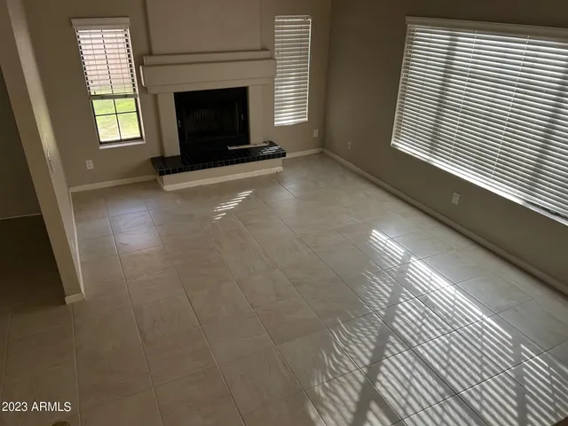 a view of an empty room with window and fire place