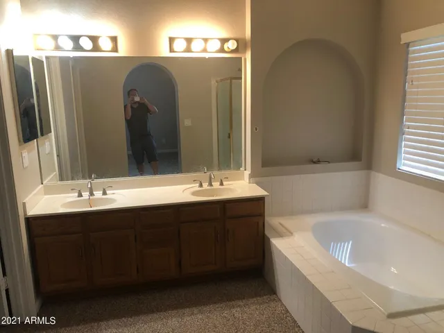 a bathroom with a bathtub sink and mirror